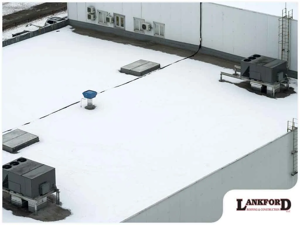 Commercial flat roof showing winter weather and ponding water issues